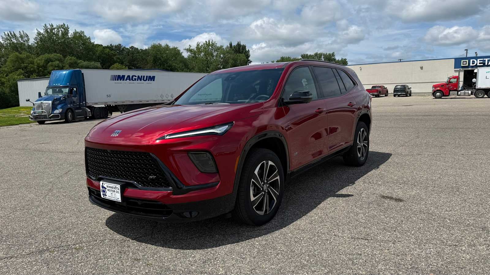 2026 Buick Enclave Sport Touring in Cherry Red Tintcoat — front three-quarter view
